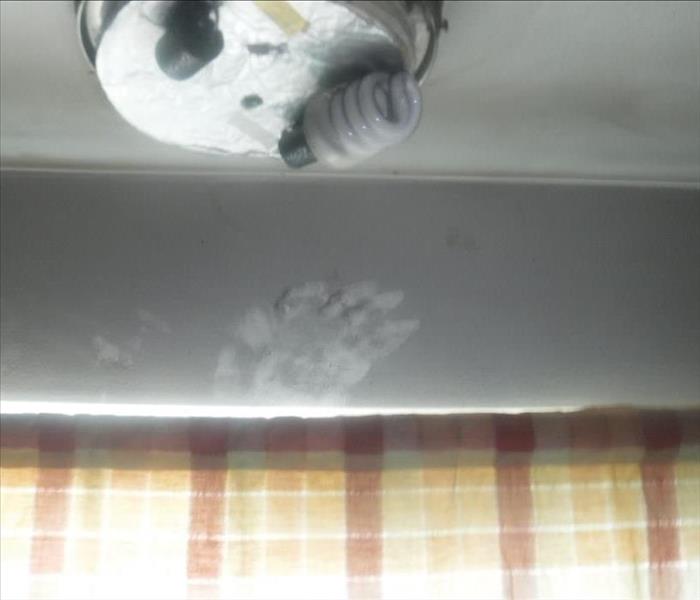 Photo shows soot residue with hand print on a Kitchen Ceiling
